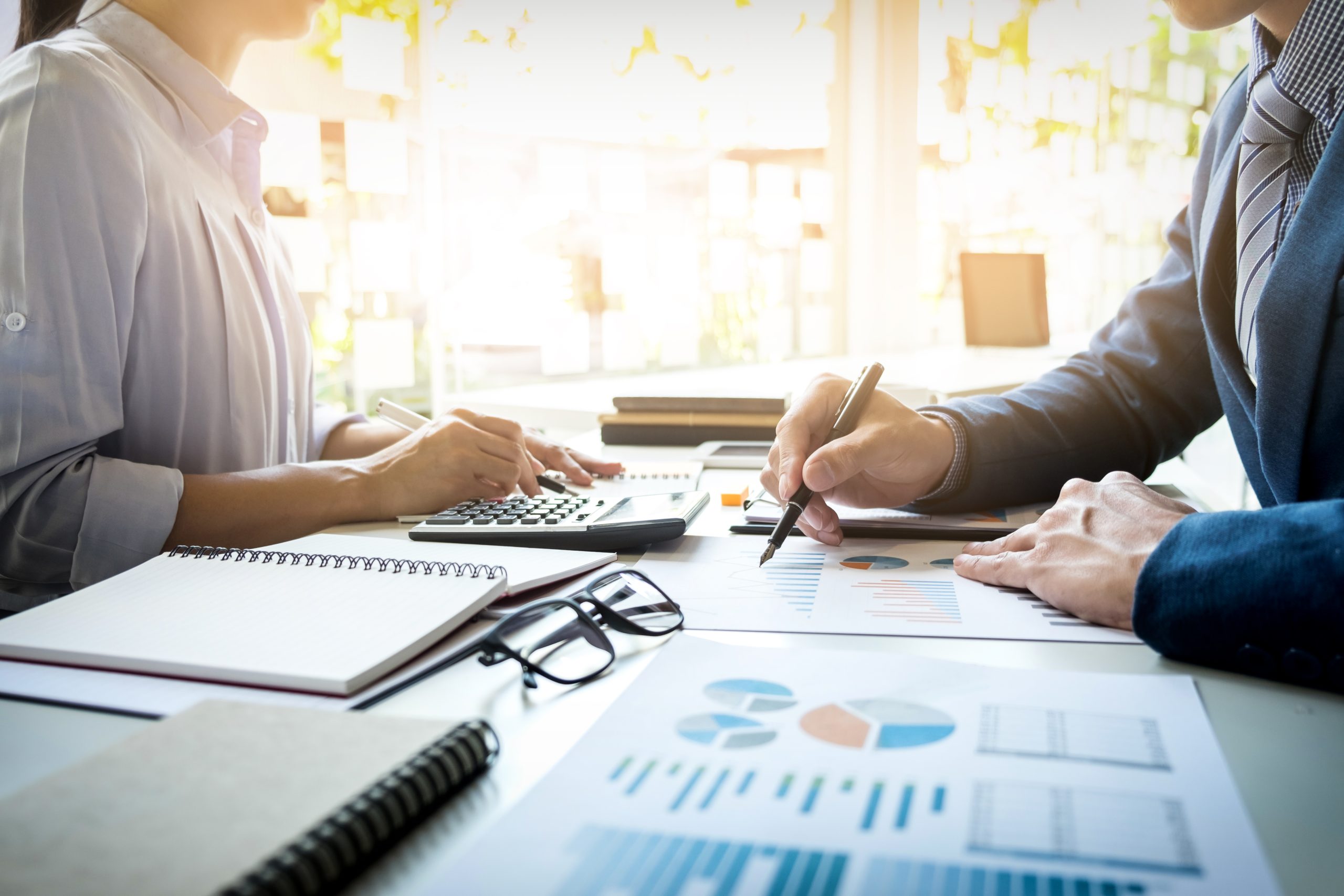 Professional handing a pen to a client for signing a contract, representing business agreements and legal documentation in a corporate setting.
