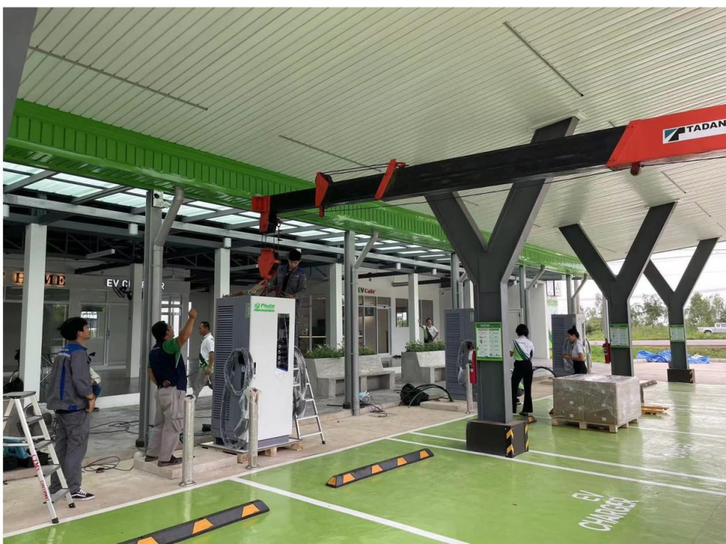 Technicians installing DC fast chargers at an EV charging station.