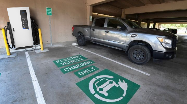 An electric car is charged using Pilot X Piwin's DC EV Charger Stations in a hotel parking lot in Paris, France.